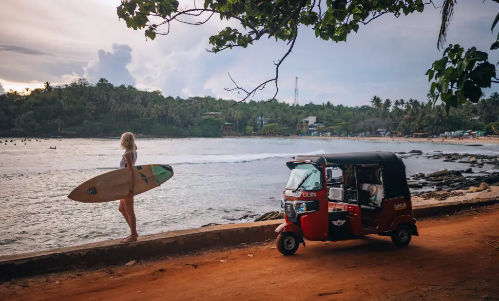 Hiriketiya Beach at golden hour — turquoise bay with surfers